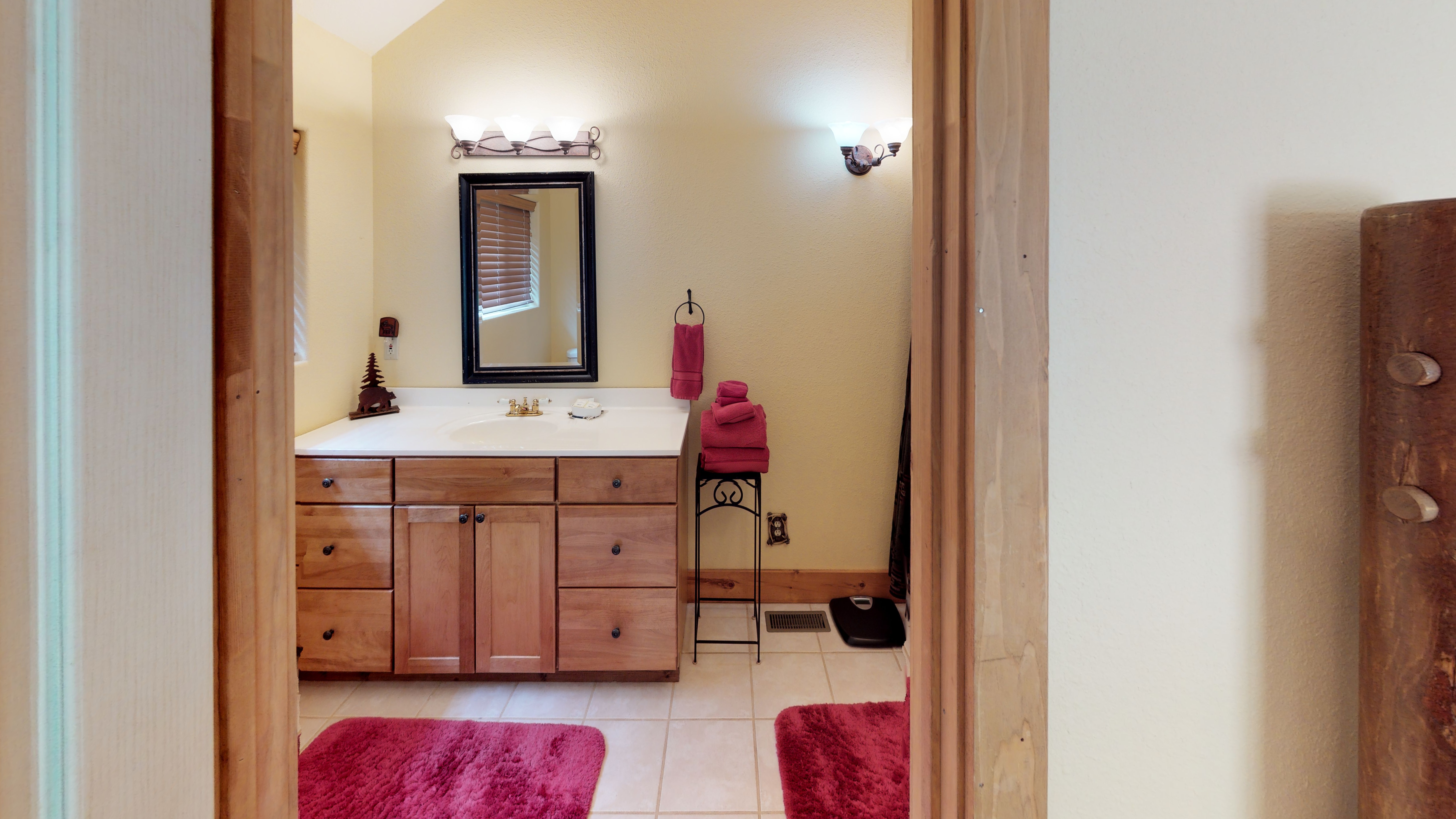 Clean bathroom with charming mountain decor, fully stocked with fluffy towels