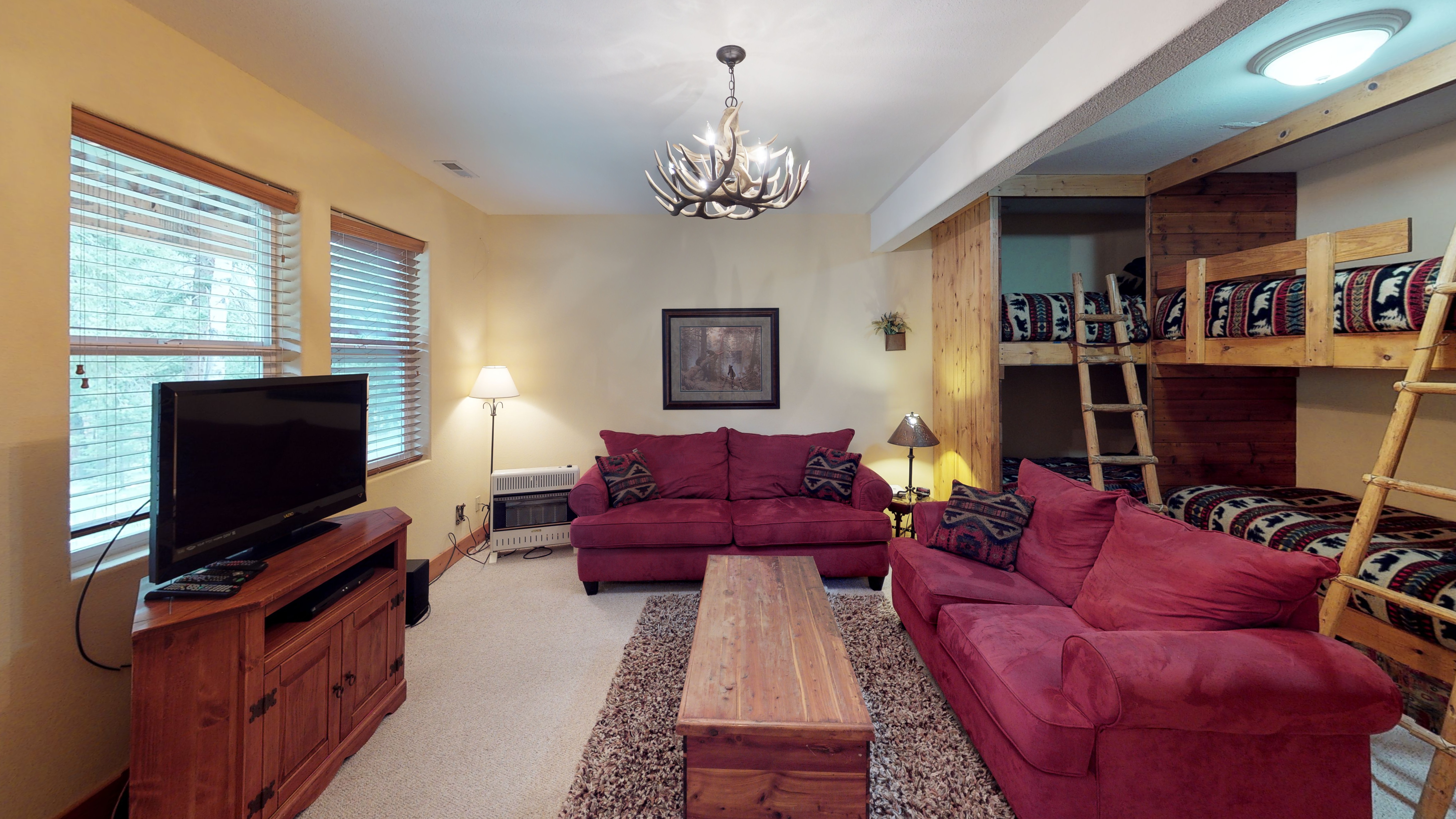 Comfortable couches and entertainment center in bedroom with two bunk beds