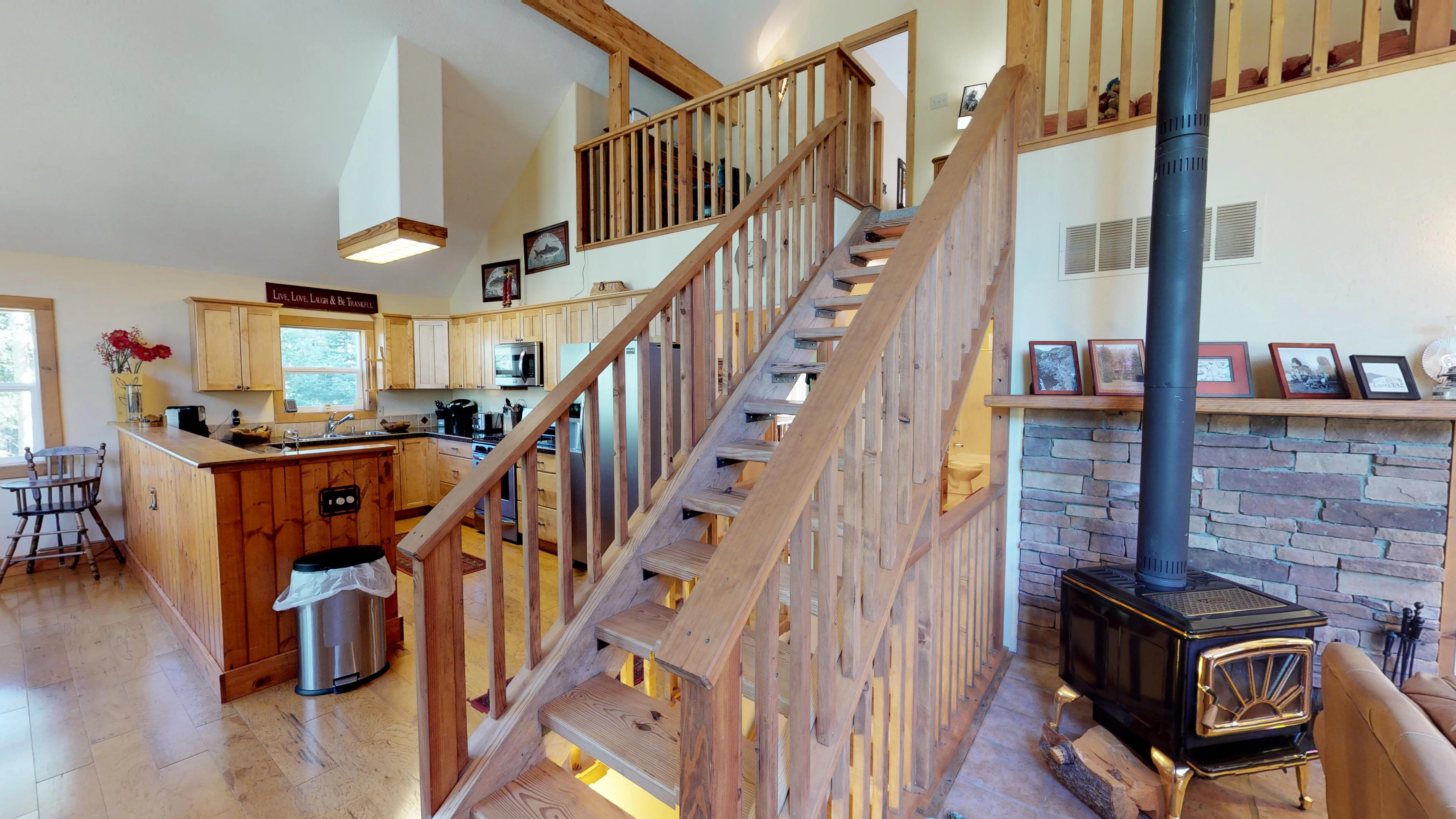 Staircase leading to the third level, and cozy wood burning stove in living room